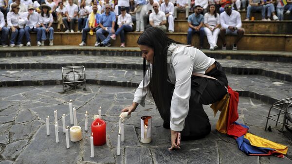 Mulher acende uma vela em uma reunião para orar pela recuperação do senador colombiano Miguel Uribe Turbay, em Cali. Colômbia, 8 de junho de 2025 - Sputnik Brasil