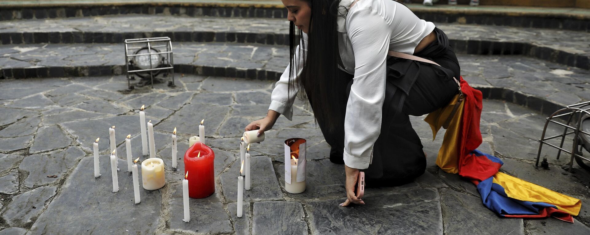 Mulher acende uma vela em uma reunião para orar pela recuperação do senador colombiano Miguel Uribe Turbay, em Cali. Colômbia, 8 de junho de 2025 - Sputnik Brasil, 1920, 27.08.2025