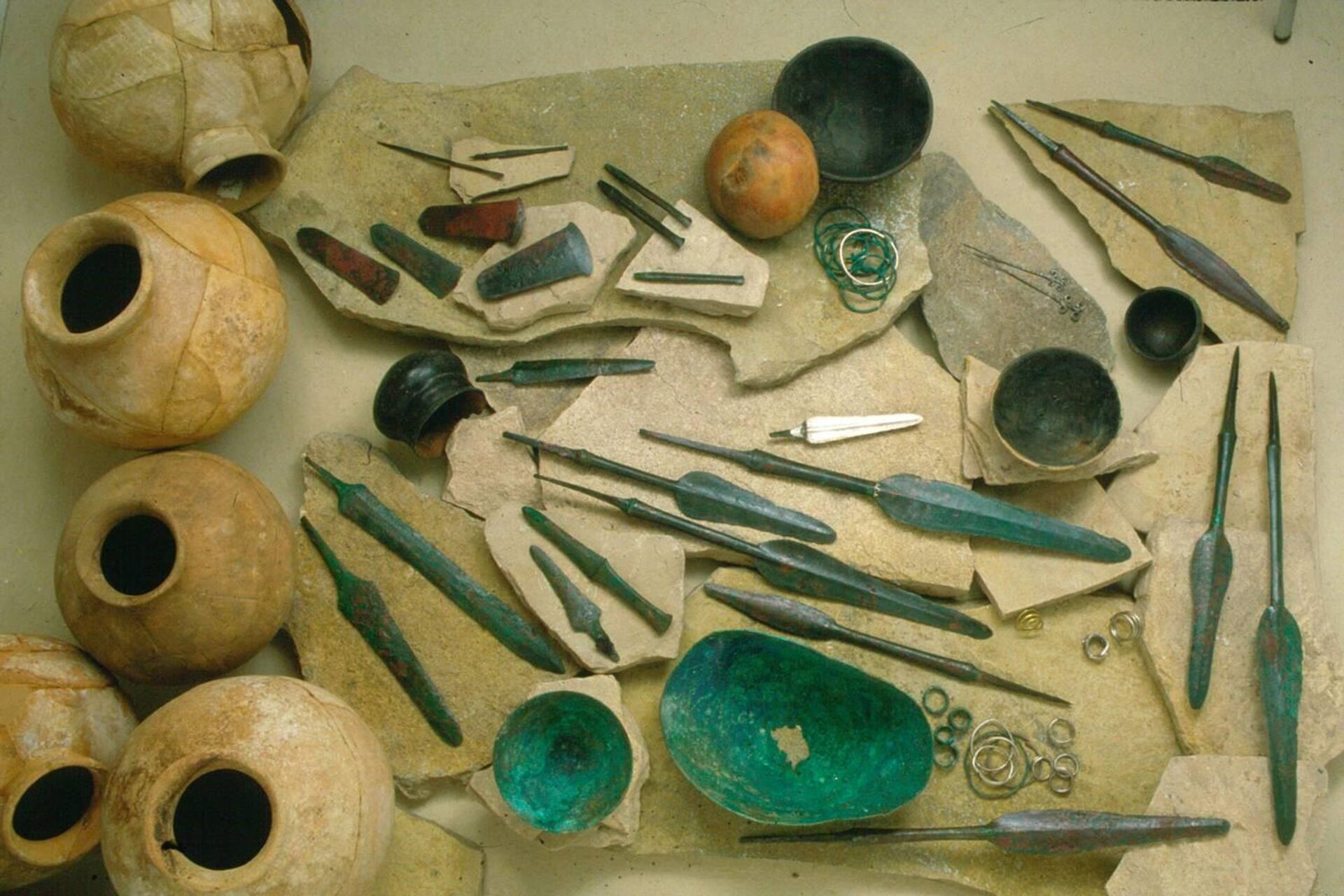 No complexo do palácio, foram descobertas armas como espadas, punhais e pontas de lança feitas de liga de cobre arsênico com incrustações de prata, além de fruteiras de pés altos e longos vasos em estilo mesopotâmico No complexo do palácio, foram descobertas armas como espadas, punhais e pontas de lança feitas de liga de cobre arsênico com incrustações de prata, além de fruteiras de pés altos e longos vasos em estilo mesopotâmico