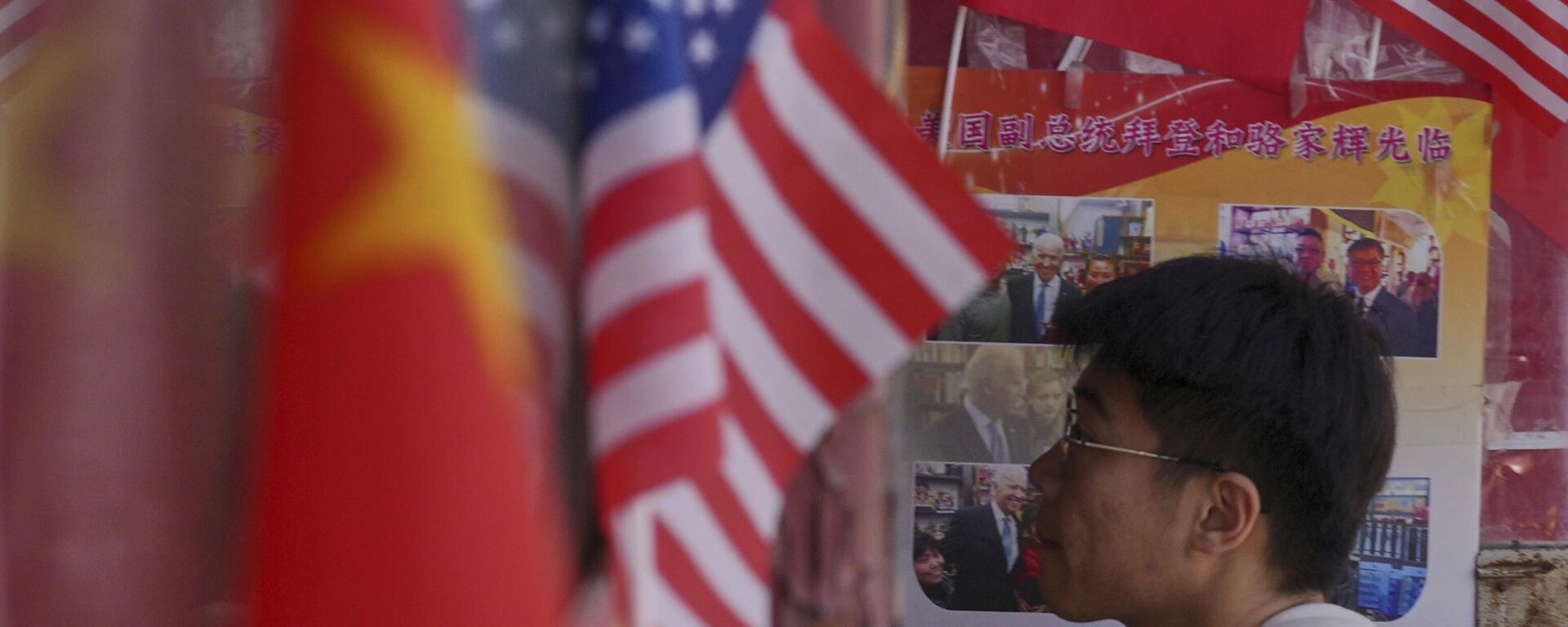 Homem entra em uma loja de produtos exibindo bandeiras nacionais da China e dos Estados Unidos, em Pequim, 3 de abril de 2025 - Sputnik Brasil, 1920, 11.06.2025