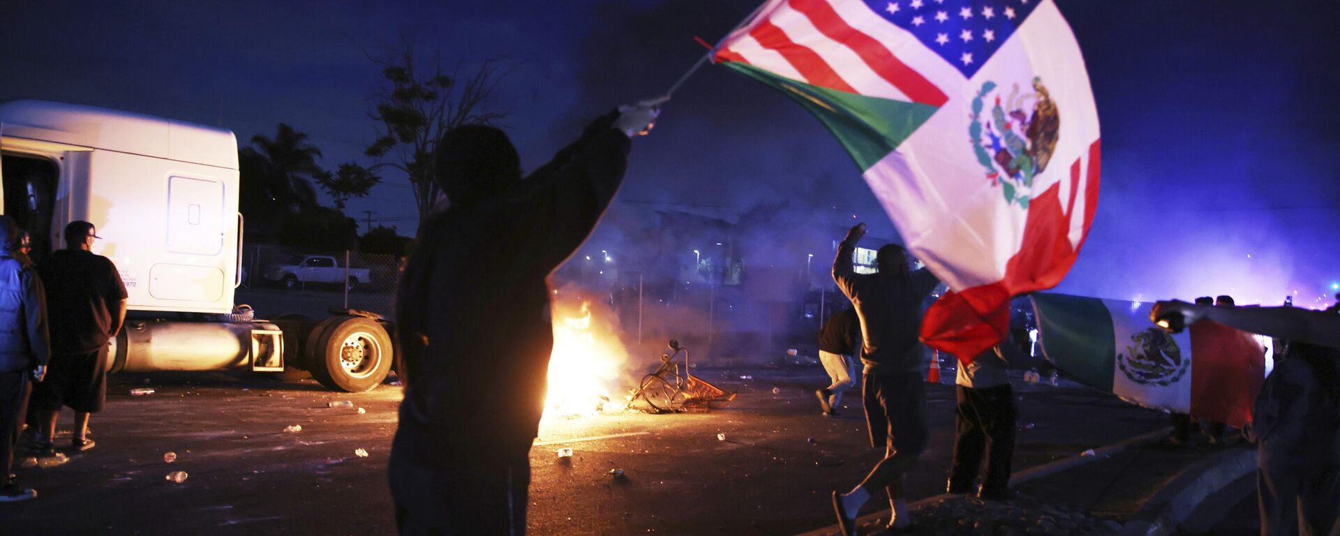 Um manifestante agita uma bandeira norte-americana e mexicana durante um protesto em Compton, Califórnia, depois que autoridades federais de imigração realizaram operações, 7 de junho de 2025 - Sputnik Brasil, 1920, 11.06.2025
