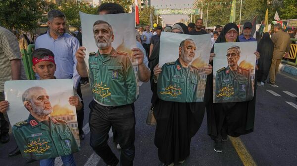 Manifestantes carregam cartazes dos principais comandantes iranianos mortos nos ataques israelenses de sexta-feira em Teerã, durante o feriado muçulmano xiita de Eid al-Ghadir, em Teerã, Irã, 14 de junho de 2025 - Sputnik Brasil