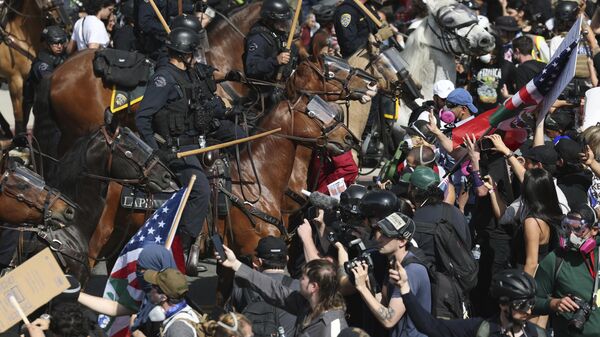Manifestantes enfrentam policiais a cavalo durante um protesto em Los Angeles, 14 de junho de 2025 - Sputnik Brasil