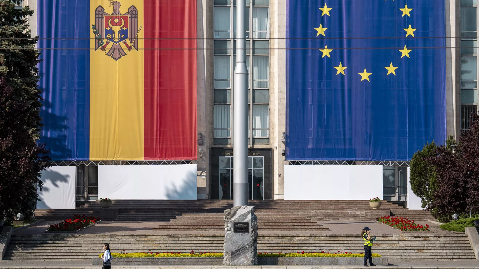 Uma mulher passa correndo pelo prédio do governo, decorado com bandeiras da União Europeia (UE) e da Moldávia, em Chisinau, Moldávia, 31 de maio de 2023 Uma mulher passa correndo pelo prédio do governo, decorado com bandeiras da União Europeia (UE) e da Moldávia, em Chisinau, Moldávia, 31 de maio de 2023 - Sputnik Brasil, 1920, 15.06.2025