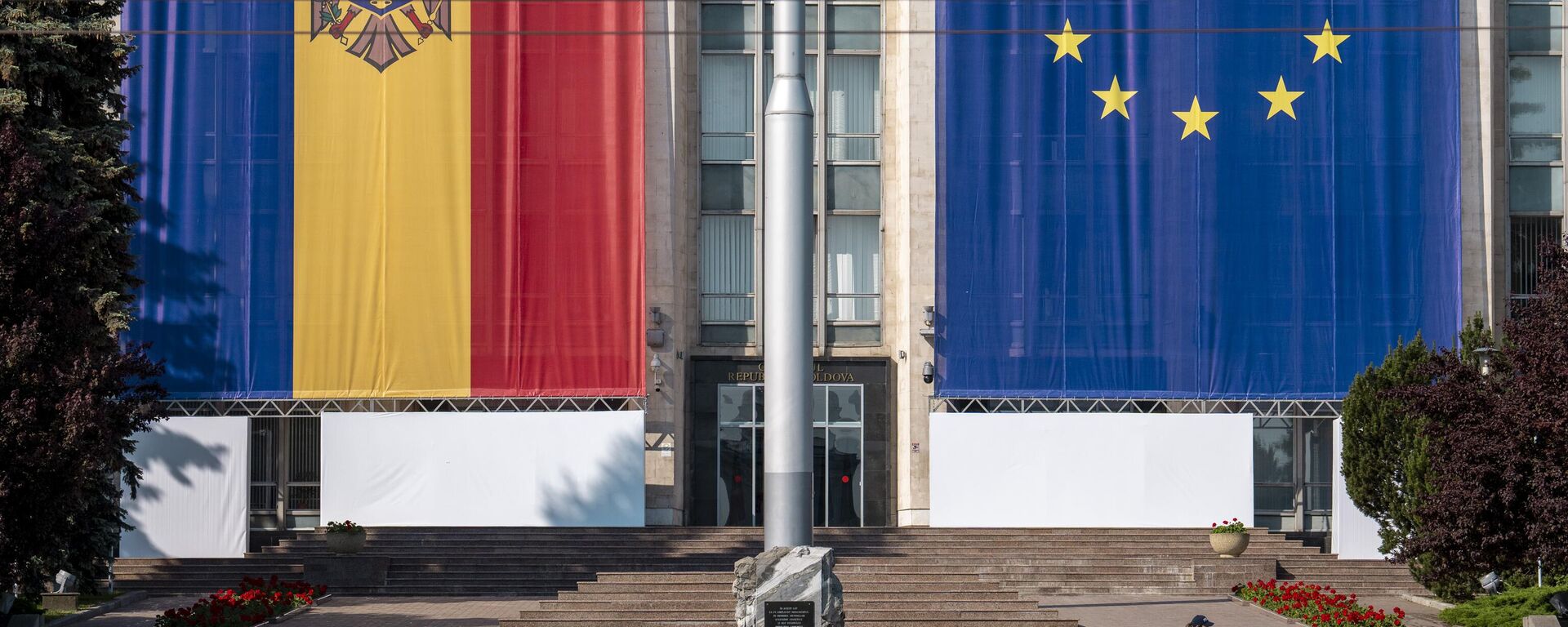 Uma mulher passa correndo pelo prédio do governo, decorado com bandeiras da União Europeia (UE) e da Moldávia, em Chisinau, Moldávia, 31 de maio de 2023 - Sputnik Brasil, 1920, 25.09.2025