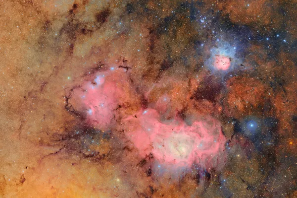 Nesta imensa imagem, o Observatório Vera C. Rubin oferece uma nova visão de duas velhas conhecidas: as Nebulosas Trífida e da Lagoa. A Nebulosa Trífida (também conhecida como Messier 20) é um destaque no céu. É uma nuvem brilhante e colorida de gás e poeira a cerca de 5.000 anos-luz de distância na constelação de Sagitário. Abaixo da Nebulosa Trífida nesta imagem está a Nebulosa da Lagoa (ou Messier 8), outro vibrante berçário estelar brilhando a cerca de 4.000 anos-luz de distância - Sputnik Brasil