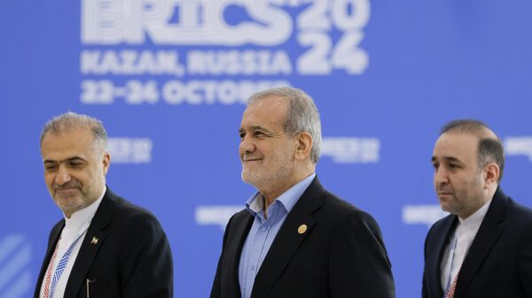 O presidente iraniano Masoud Pezeshkian, ao centro, acompanhado pelo embaixador iraniano na Rússia, Kazem Jalali, à esquerda, chega à Cúpula do BRICS em Kazan, Rússia, 23 de outubro de 2024 - Sputnik Brasil