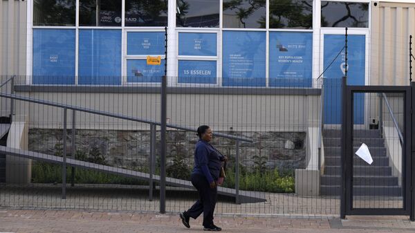 Uma mulher passa por uma clínica do Instituto de Saúde Reprodutiva WITS (RHI, na sigla em inglês) fechada enquanto uma placa no portão diz: A USAID enviou ao Programa de Populações-Chave do WITS RHI um aviso para suspender a implementação do programa. A partir de terça-feira, 28 de janeiro, não poderemos prestar serviços até novo aviso, em Hillbrow, Joanesburgo, África do Sul, 27 de fevereiro de 2025 - Sputnik Brasil