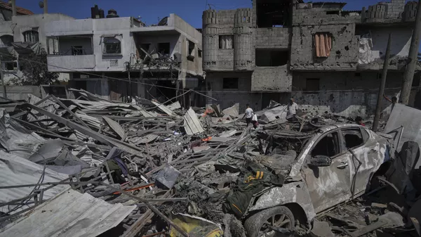 Palestinos inspecionam os destroços de um posto de gasolina destruído em um ataque aéreo israelense em Deir al-Balah. Faixa de Gaza, 12 de julho de 2025 - Sputnik Brasil