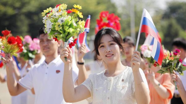 Pessoas dão as boas-vindas à chegada da delegação russa liderada por Alexander Kozlov, ministro de Recursos Naturais e Ecologia, no Aeroporto Internacional de Pyongyang, em Pyongyang, Coreia do Norte, 28 de julho de 2025 - Sputnik Brasil