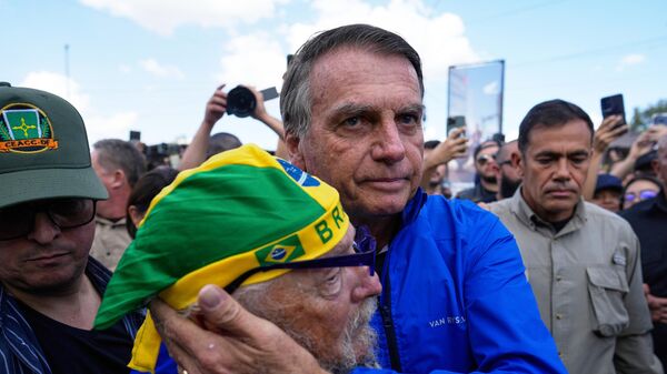 O ex-presidente do Brasil Jair Bolsonaro abraça apoiador durante motociata, em Brasília, no Distrito Federal. 29 de julho de 2025. - Sputnik Brasil