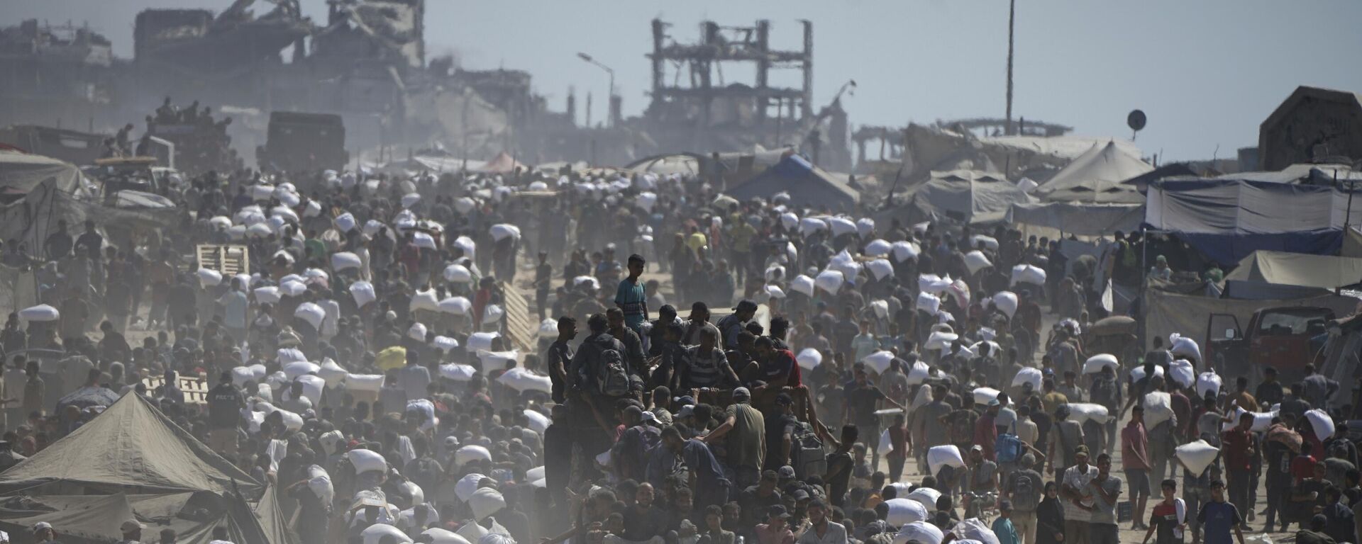 Palestinos carregam sacos de farinha retirados de um comboio de ajuda humanitária a caminho da cidade de Gaza, nos arredores de Beit Lahiya, no norte da Faixa de Gaza, em 1º de agosto de 2025 - Sputnik Brasil, 1920, 05.08.2025