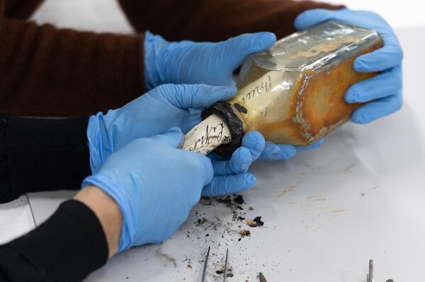 No detalhe, a remoção do manuscrito, manipulado com extremo cuidado devido à idade do papel - Sputnik Brasil