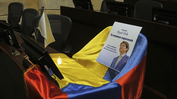 Um folheto mostrando o senador colombiano Miguel Uribe Turbay sentado em uma bandeira nacional colombiana posta sobre seu assento na Câmara do Congresso em Bogotá, Colômbia, em 9 de junho de 2025. - Sputnik Brasil