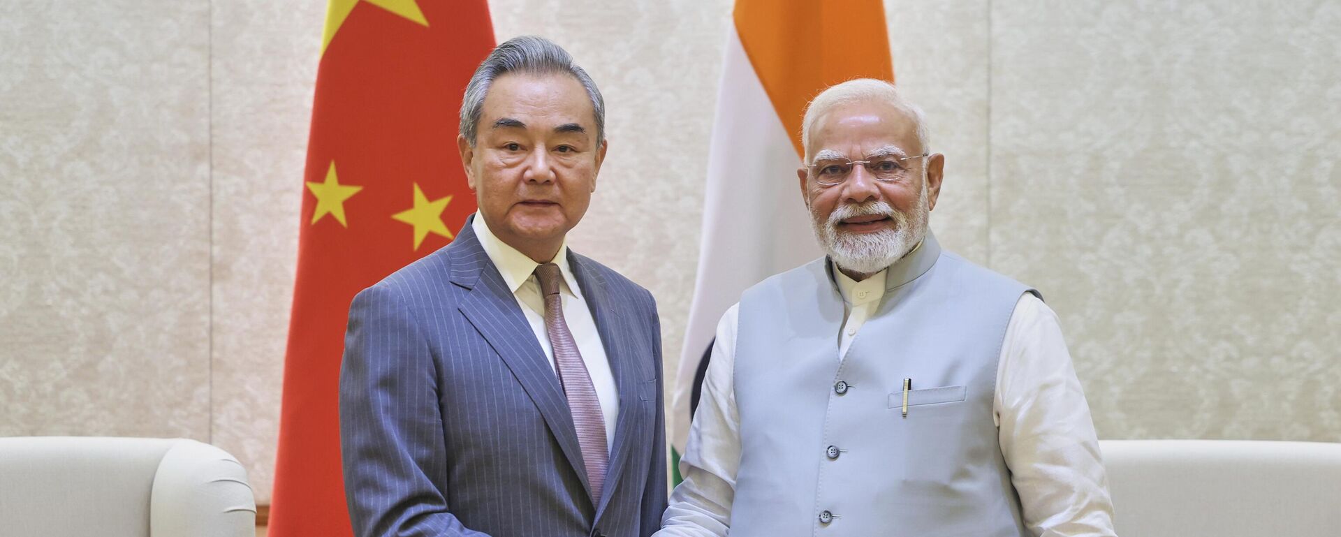 O primeiro-ministro indiano Narendra Modi (D), aperta a mão do ministro das Relações Exteriores chinês Wang Yi, em Nova Deli, Índia, 19 de agosto de 2025 - Sputnik Brasil, 1920, 20.08.2025