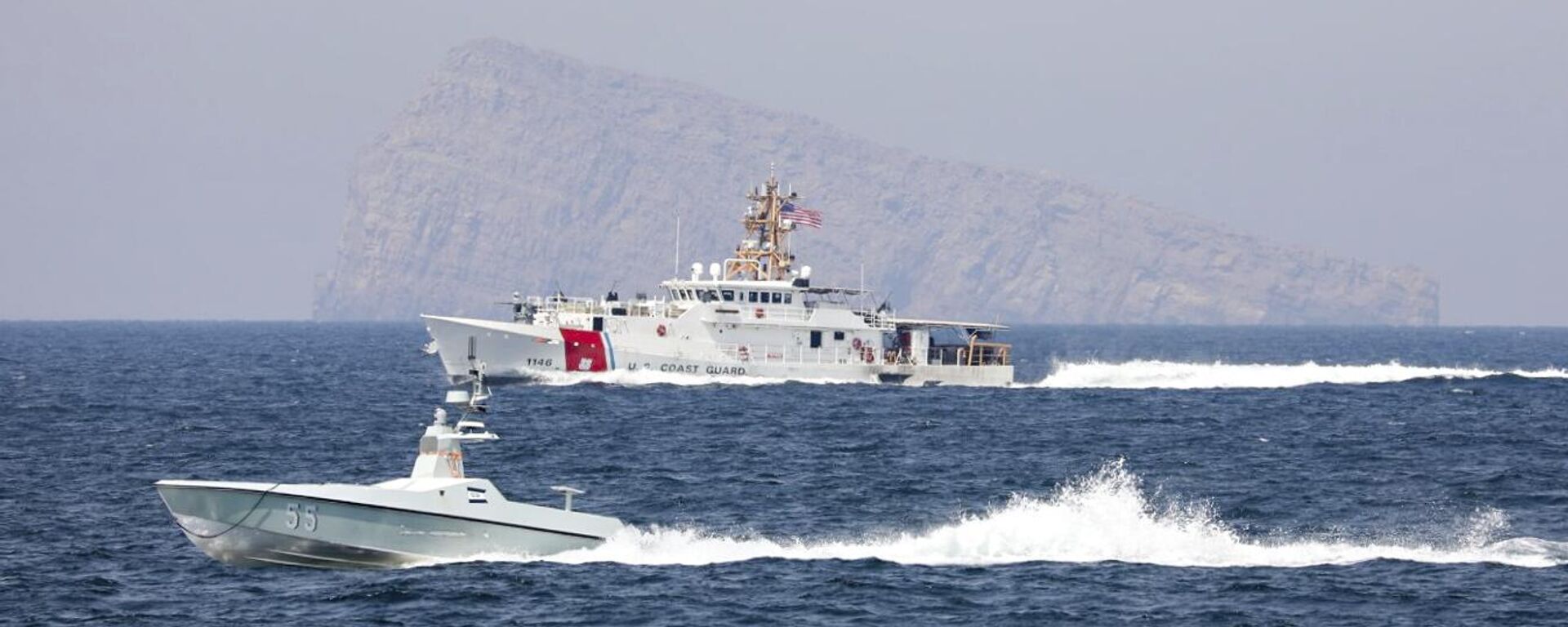 Uma embarcação autônoma Arabian Fox MAST-13, da Marinha dos EUA e da L3Harris, e o cúter USCGC John Scheuerman, da Guarda Costeira dos EUA, transitam pelo Estreito de Ormuz na quarta-feira, 19 de abril de 2023 - Sputnik Brasil, 1920, 23.12.2025