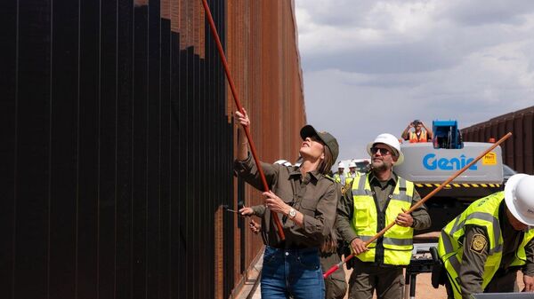 A secretária de Segurança Interna dos EUA, Kristi Noem, pintando o muro da fronteira com o México - Sputnik Brasil