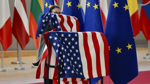 Um membro do protocolo ajusta as bandeiras dos EUA e da UE antes da chegada do secretário de Estado dos EUA, Antony Blinken, e do presidente do Conselho Europeu, Charles Michel, durante uma reunião extraordinária dos ministros das Relações Exteriores da UE no edifício do Conselho Europeu em Bruxelas, sexta-feira, 4 de março de 2022. - Sputnik Brasil