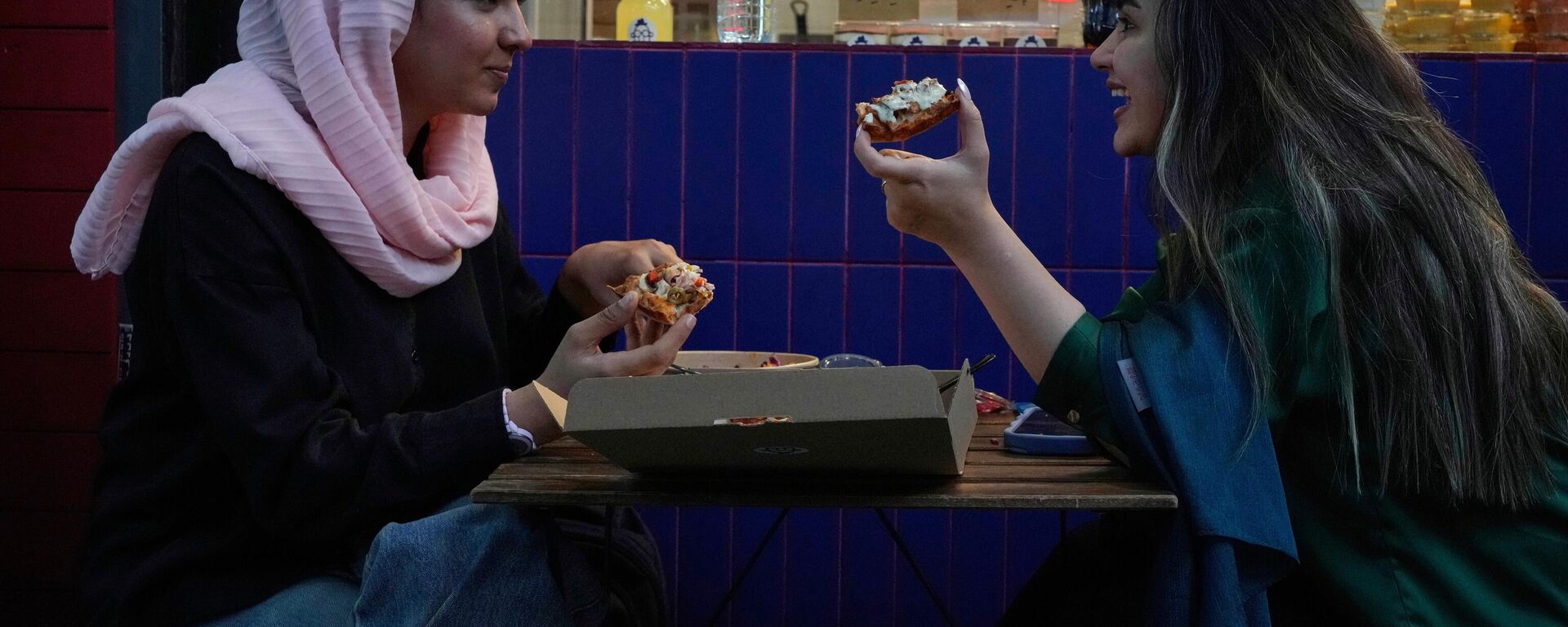 Mulheres comem pizza na área externa de um restaurante no norte de Teerã. Irã, 2 de junho de 2025 - Sputnik Brasil, 1920, 21.08.2025