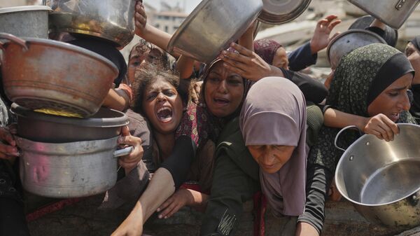 Palestinos lutam para receber doações de alimentos em cozinha comunitária na cidade de Gaza, região norte da Faixa de Gaza - Sputnik Brasil