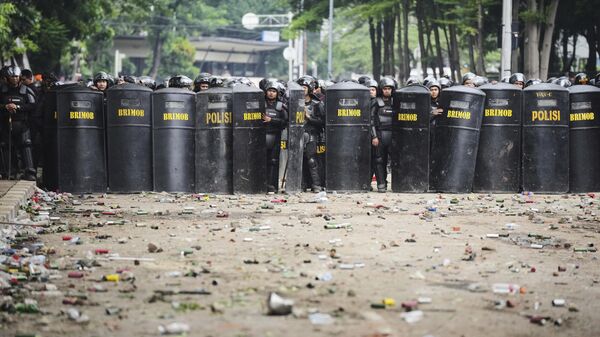 Entulhos cobrem as ruas enquanto policiais tomam posição após protestos violentos contra o subsídio dos legisladores e a brutalidade policial depois que um entregador foi supostamente atropelado por um veículo blindado da polícia durante confrontos entre a polícia de choque e estudantes manifestantes, em Jacarta, Indonésia, 30 de agosto de 2025 - Sputnik Brasil