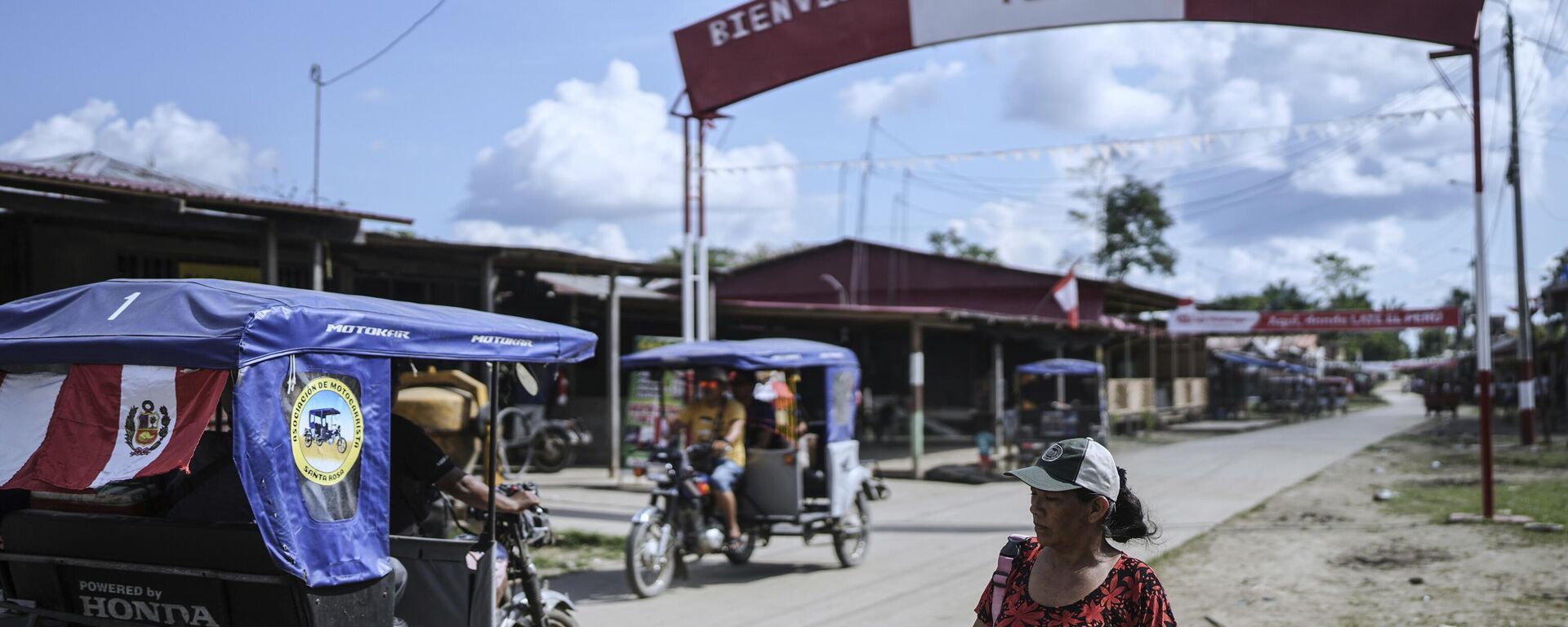 Pessoas caminham por uma rua com uma placa de boas-vindas a Santa Rosa, no Peru, uma ilha no rio Amazonas - Sputnik Brasil, 1920, 02.09.2025