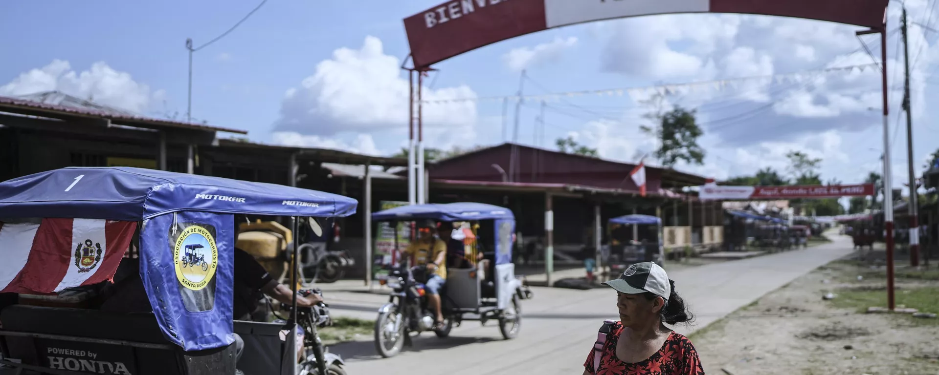 Pessoas caminham por rua com uma placa de boas-vindas a Santa Rosa, Peru, uma ilha no rio Amazonas - Sputnik Brasil, 1920, 21.10.2025