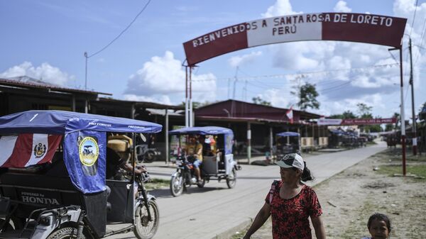 Pessoas caminham por uma rua com uma placa de boas-vindas a Santa Rosa, no Peru, uma ilha no rio Amazonas - Sputnik Brasil