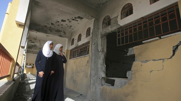 Estudantes palestinas inspecionam os danos em sua escola na Cidade de Gaza. - Sputnik Brasil