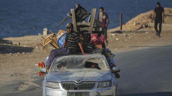 Palestinos deslocados fugindo do norte de Gaza carregam seus pertences em um carro ao longo da estrada costeira em direção ao sul de Gaza, 5 de setembro de 2025. - Sputnik Brasil