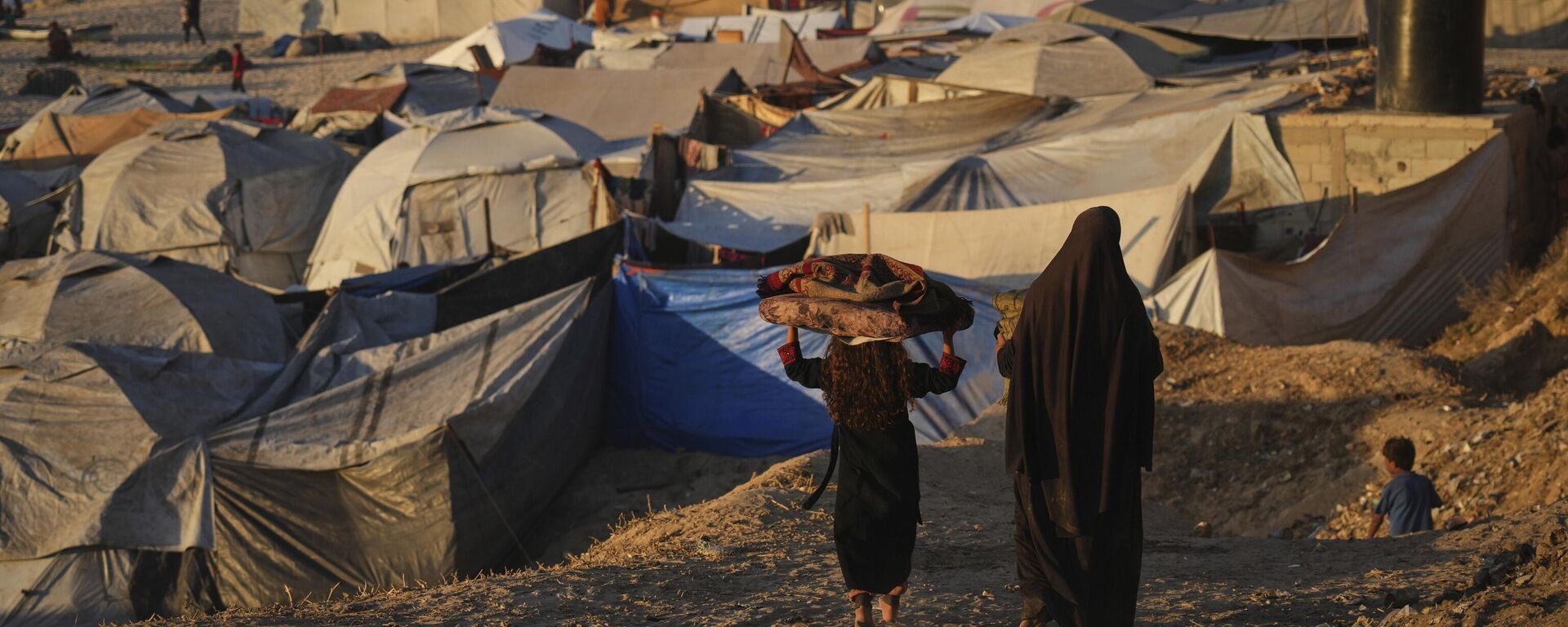 Palestinos deslocados caminham por um acampamento improvisado ao longo da costa de Deir al-Balah, na Faixa de Gaza, em setembro de 2025 - Sputnik Brasil, 1920, 16.09.2025