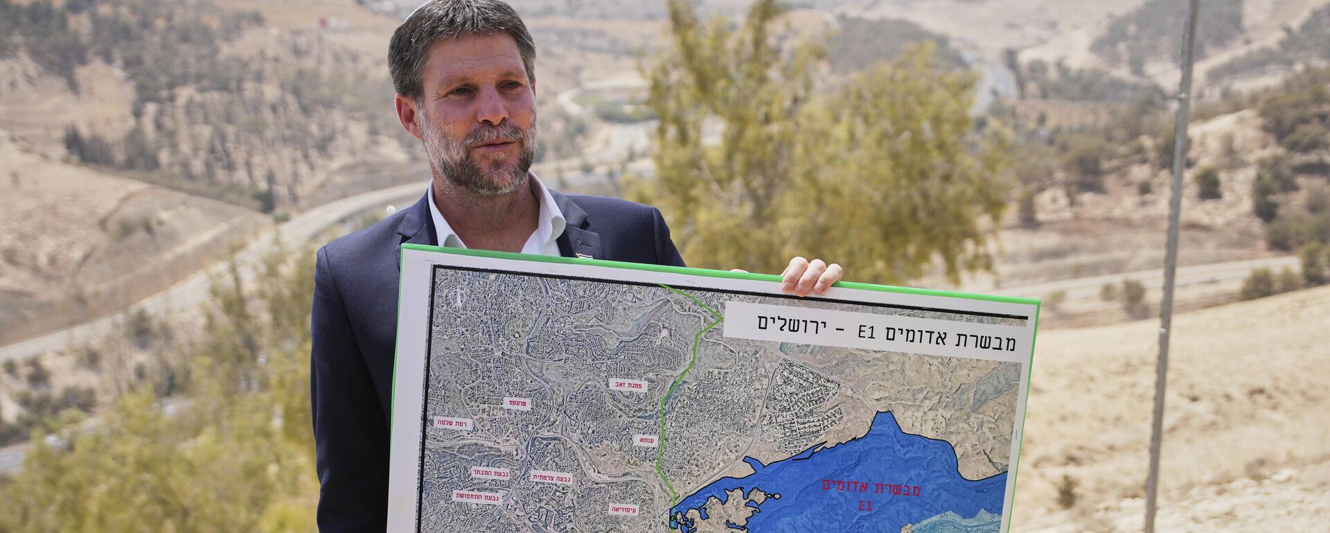 O ministro das Finanças israelense, Bezalel Smotrich, segura um mapa que mostra o projeto de assentamento E1 durante uma coletiva de imprensa perto do assentamento de Maale Adumim, na Cisjordânia ocupada por Israel, em agosto de 2025 - Sputnik Brasil, 1920, 17.09.2025
