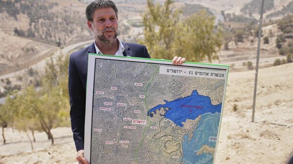 O ministro das Finanças israelense, Bezalel Smotrich, segura um mapa que mostra o projeto de assentamento E1 durante uma coletiva de imprensa perto do assentamento de Maale Adumim, na Cisjordânia ocupada por Israel, em agosto de 2025 - Sputnik Brasil