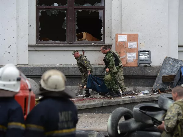 Milicianos populares transportam uma vítima mortal do ataque aéreo da Força Aérea Ucraniana contra o prédio da administração regional em Lugansk Milicianos populares transportam uma vítima mortal do ataque aéreo da Força Aérea Ucraniana contra o prédio da administração regional em Lugansk - Sputnik Brasil