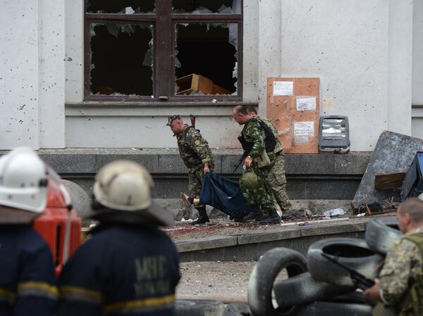 Milicianos populares transportam uma vítima mortal do ataque aéreo da Força Aérea Ucraniana contra o prédio da administração regional em Lugansk Milicianos populares transportam uma vítima mortal do ataque aéreo da Força Aérea Ucraniana contra o prédio da administração regional em Lugansk - Sputnik Brasil