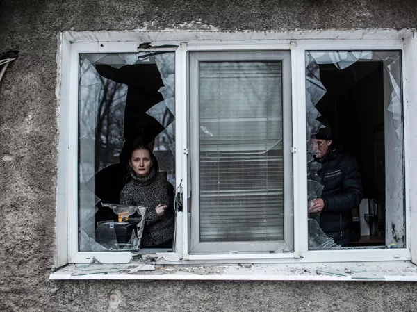 Uma mulher olha através de uma janela quebrada de seu apartamento depois que ele foi atingido pela artilharia ucraniana na área de Voroshilovsky, no centro de Donetsk, Ucrânia. Uma mulher olha através de uma janela quebrada de seu apartamento depois que ele foi atingido pela artilharia ucraniana na área de Voroshilovsky, no centro de Donetsk, Ucrânia. - Sputnik Brasil