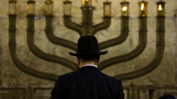 Judeu ultraortodoxo em frente a uma menorá na terceira véspera do Chanucá, no Muro das Lamentações, o local mais sagrado do judaísmo, na Cidade Velha de Jerusalém, em 13 de dezembro de 2009 - Sputnik Brasil