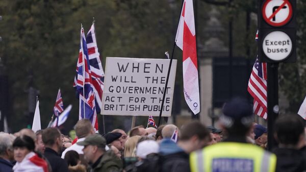 Manifestantes de extrema-direita protestam atrás de uma barreira policial em Londres. Reino Unido, 26 de outubro de 2024 - Sputnik Brasil
