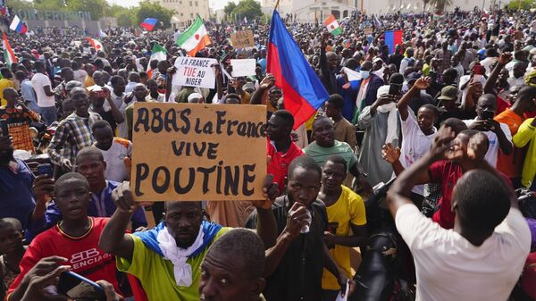 Povo nigerino comemora saída das tropas francesas do país, em julho de 2023. Cartaz em francês diz: Abaixo à França, viva Putin - Sputnik Brasil