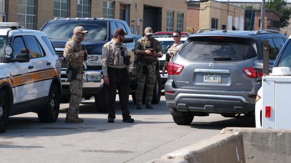 Agentes da Patrulha Federal e policiais do Xerife do Condado de Cook estão perto da entrada de uma unidade de processamento do Serviço de Imigração e Alfândega dos EUA (ICE, na sigla em inglês) no subúrbio de Broadview, Illinois, em Chicago, 6 de outubro de 2025 - Sputnik Brasil