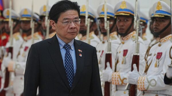 O primeiro-ministro de Cingapura, Lawrence Wong, passa em revista a guarda honorária ao chegar para uma reunião de boas-vindas com seu homólogo cambojano, Hun Manet, no Palácio da Paz em Phnom Penh, Camboja, 2 de julho de 2025 - Sputnik Brasil