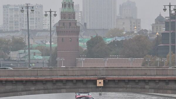 Barcos de passeio navegam pelo rio Moscou, passando pela ponte Bolshoi Moskvoretsky, com a torre Vodovzvodnaya do Kremlin e a sede do Ministério das Relações Exteriores da Rússia ao fundo, envoltos pela névoa da manhã - Sputnik Brasil