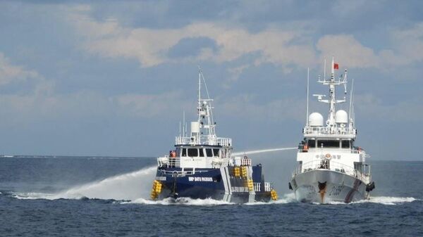 Navio da Guarda Costeira chinesa (D), dispara seu canhão de água contra o BRP Datu Pagbuaya das Filipinas, perto da ilha de Thitu ocupada pelas Filipinas, no mar do Sul da China, 12 de outubro de 2025 - Sputnik Brasil