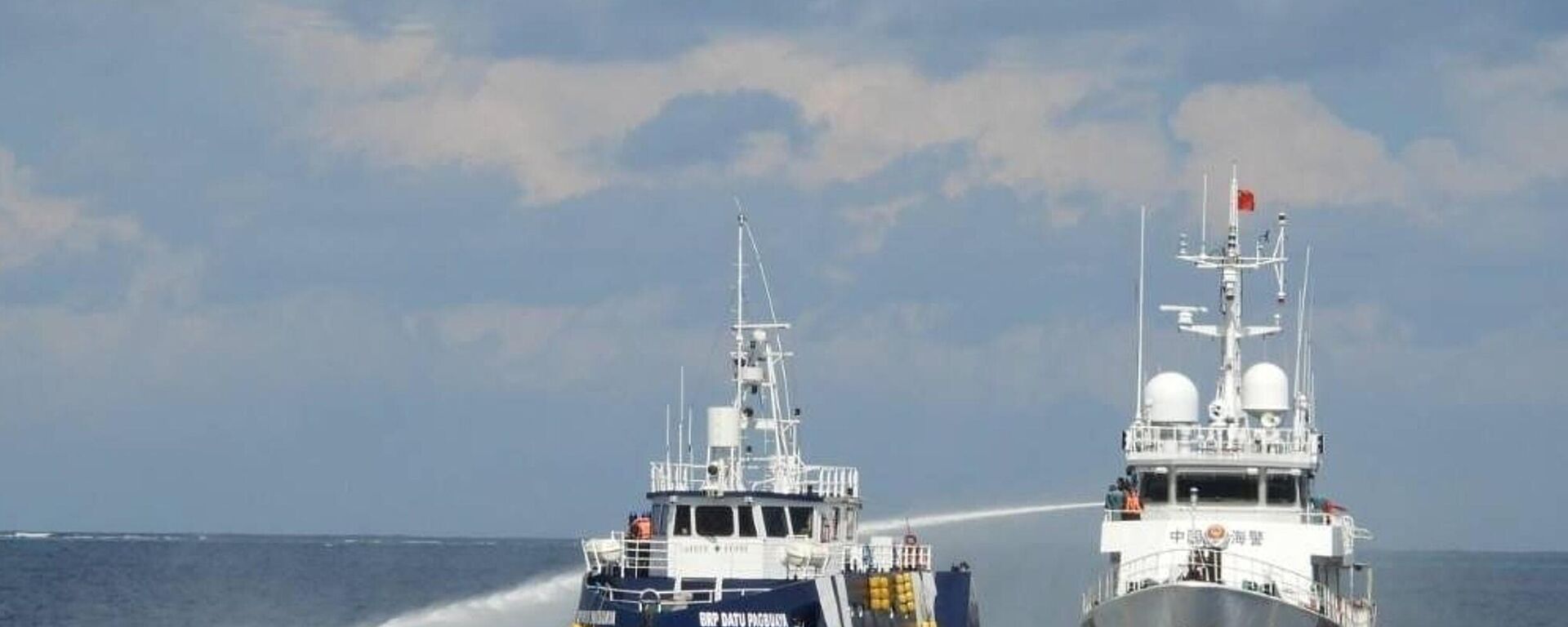 Navio da Guarda Costeira chinesa (D), dispara seu canhão de água contra o BRP Datu Pagbuaya das Filipinas, perto da ilha de Thitu ocupada pelas Filipinas, no mar do Sul da China, 12 de outubro de 2025 - Sputnik Brasil, 1920, 17.02.2026
