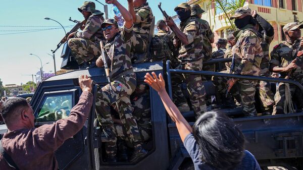 Soldados são recebidos por pessoas reunidas para uma cerimônia em homenagem aos manifestantes mortos durante um recente protesto antigovernamental em Antananarivo, Madagascar, 12 de outubro de 2025 - Sputnik Brasil