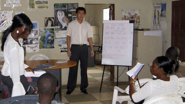 Estudantes liberianos ouvem o professor de chinês dando uma aula de mandarim no estádio Samuel Doe, em Monróvia. Libéria, 7 de outubro de 2009 - Sputnik Brasil