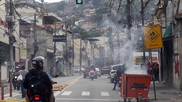 Durante operação da policia contra o Comando Vermelho nos complexos da Penha e Alemão, no Rio de Janeiro, bandidos ordenam fechamento de comércio e usam lixeiras incendiadas para bloquear a via na rua Itapiru, no Catumbi, 28 de outubro de 2025 - Sputnik Brasil