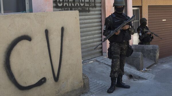 Soldado faz guarda ao lado de muro marcado com a sigla CV identificando a organização criminosa Comando Vermelho durante operação na favela da Rocinha, no Rio de Janeiro. - Sputnik Brasil