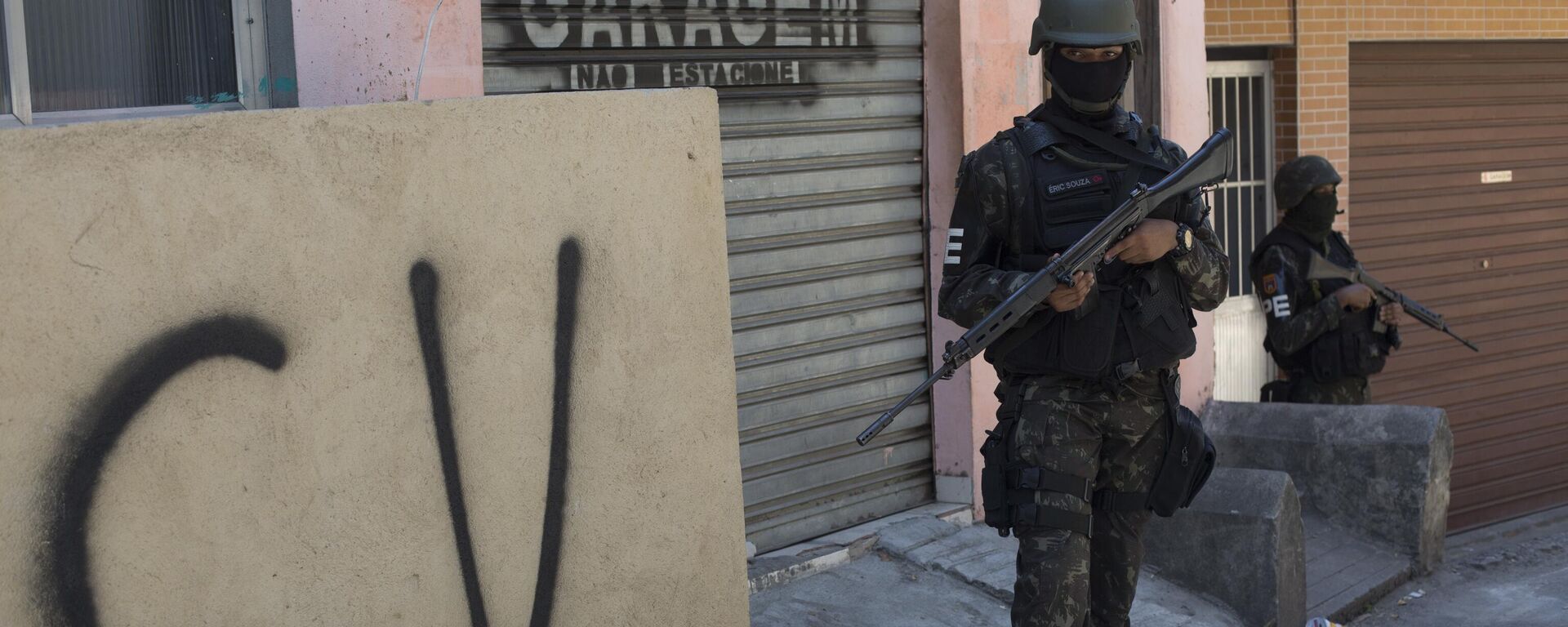 Soldado faz guarda ao lado de muro marcado com a sigla CV identificando a organização criminosa Comando Vermelho durante operação na favela da Rocinha, no Rio de Janeiro. - Sputnik Brasil, 1920, 02.11.2025