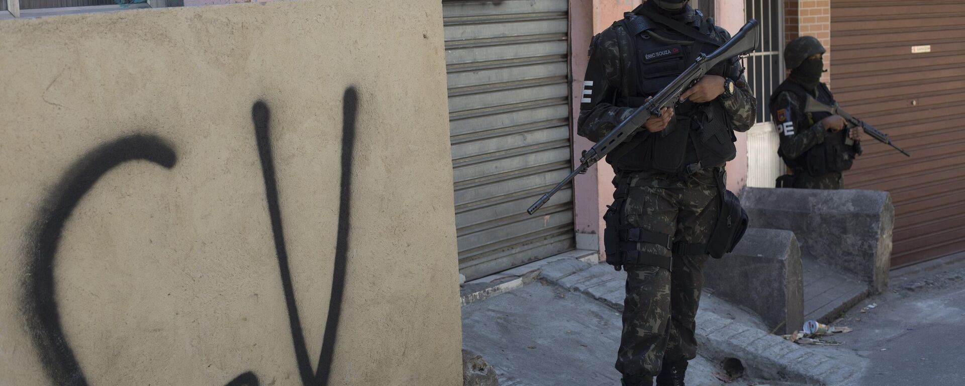 Soldado faz guarda ao lado de muro marcado com a sigla CV identificando a organização criminosa Comando Vermelho durante operação na favela da Rocinha, no Rio de Janeiro. - Sputnik Brasil, 1920, 02.11.2025